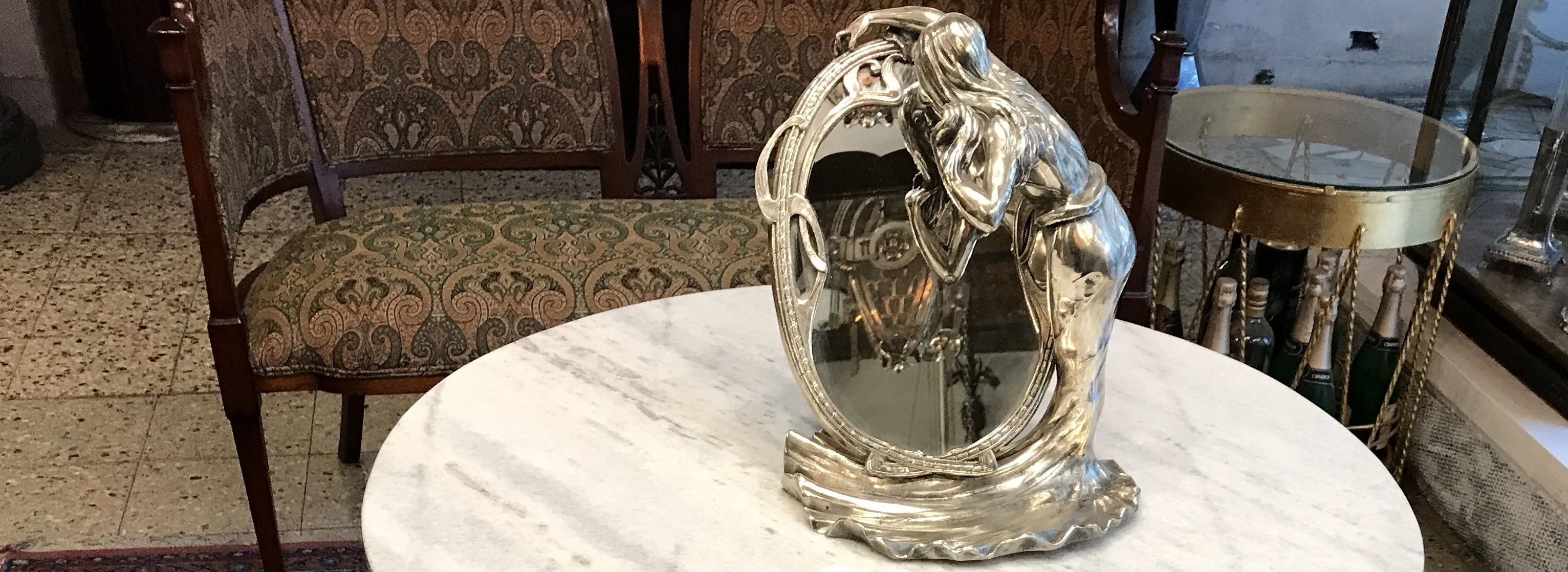 Antique decorative mirror on a marble table, elegant background.